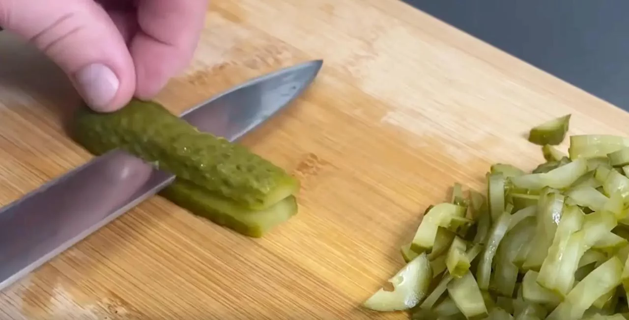 Нарежьте соленые огурцы