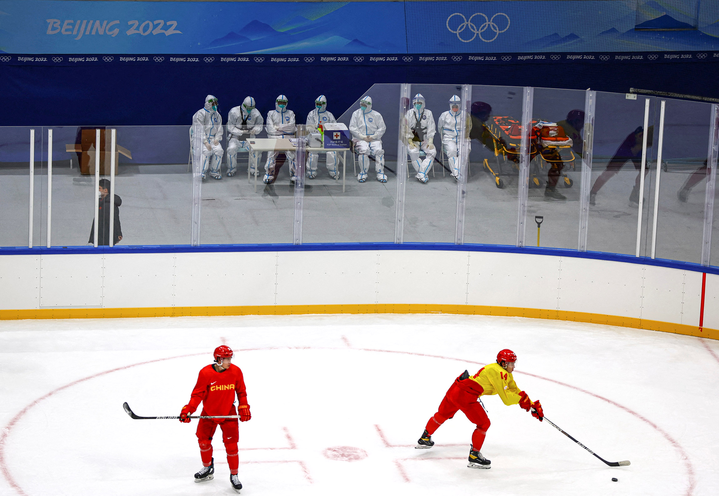 На фото:&nbsp;парамедики в защитных костюмах наблюдают за тренировкой китайской хоккейной команды.

Организаторы Олимпиады сообщили, что, в случае&nbsp;если один из членов какой-либо команды сдаст положительный тест на коронавирус, всю сборную отстранять не будут