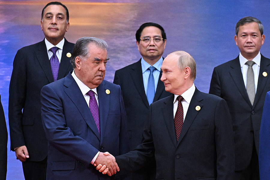 Путин пожимает руку президенту Таджикистана Эмомали Рахмону во время церемонии фотографирования на саммите ШОС.