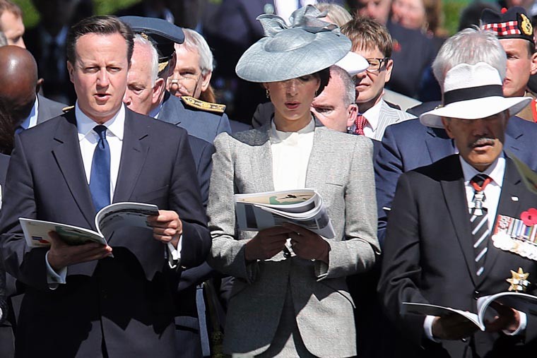 Премьер-министр Великобритании и его супруга Саманта поют во время памятной службы на кладбище в Байе.