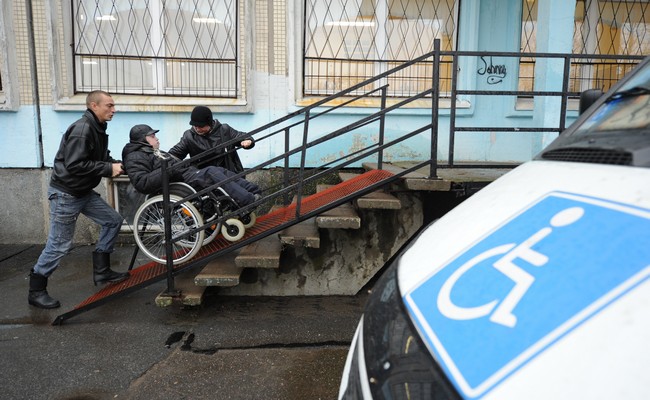 Инвалид-колясочник поднимается по пандусу