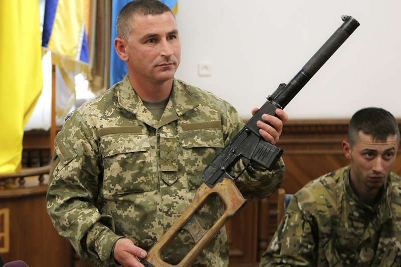 Командующий 92-й бригады Виктор Николюк показывает винтовку, изъятую у российских граждан, задержанных близ города Счастье Луганской области