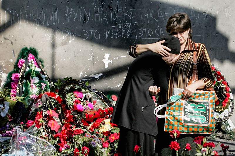 Сразу после трагедии люди в память о погибших детях начали нести к зданию школы цветы и мягкие игрушки. В Северной Осетии на протяжении нескольких недель проходили акции с требованиями наказать виновников теракта. На фото - родственники погибших заложников у здания школы. 10 сентября 2004 года 