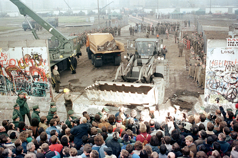 Бульдозер сносит Берлинскую стену на Потсдамер-плац для создания еще одного пункта прохода через границу. 12 ноября 1989 года