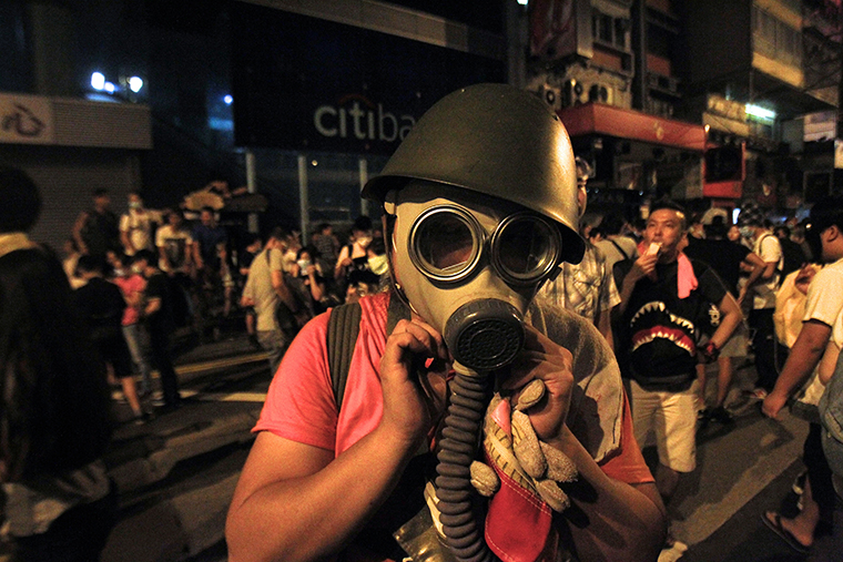 Торговый район Гонконга. Протестующий готовится к возможной атаке слезоточивым газом.