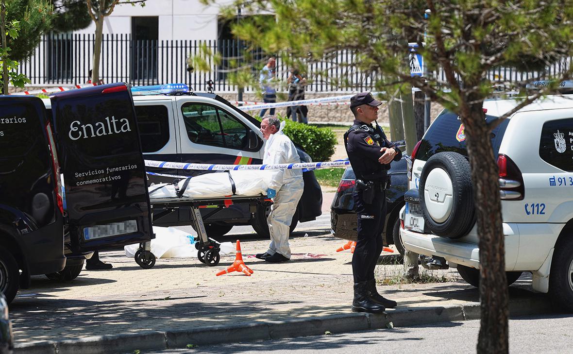 Работники похоронного бюро выносят тело Андрея Портнова от ворот Американской школы в Мадриде