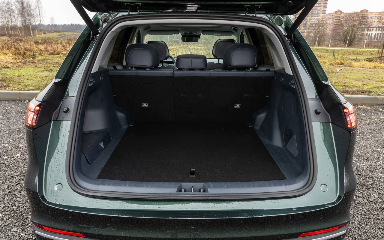 Сама отделка трюма в Geely EX5 EM-i аскетичная, а пластик грубый. Но и повредить грузами его будет сложно