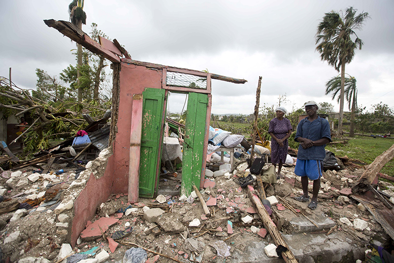 Жители Ле-Ке (Гаити) на обломках своего дома


