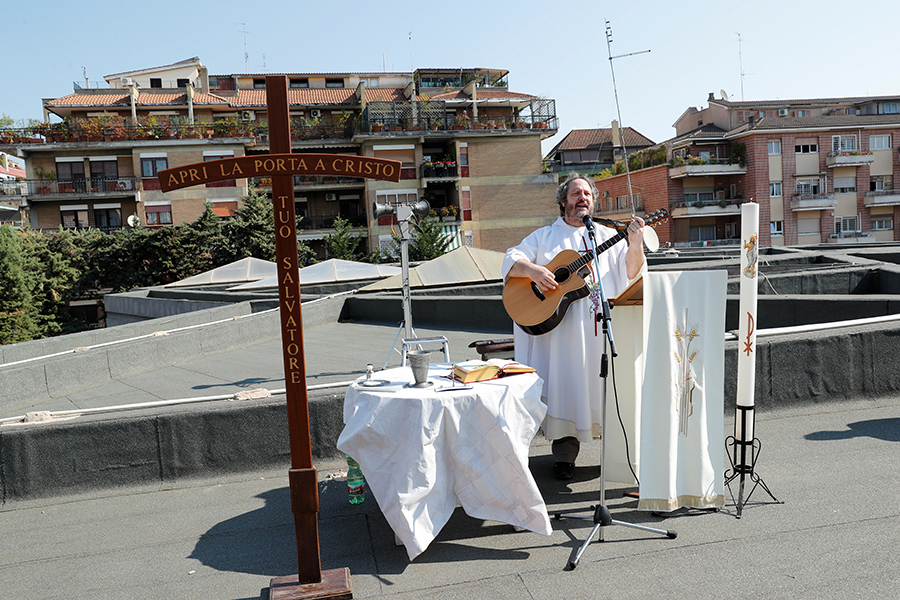 Священник проводит пасхальное воскресное богослужение, играя на гитаре на крыше церкви во время вспышки коронавирусной инфекции в Риме
&nbsp;
