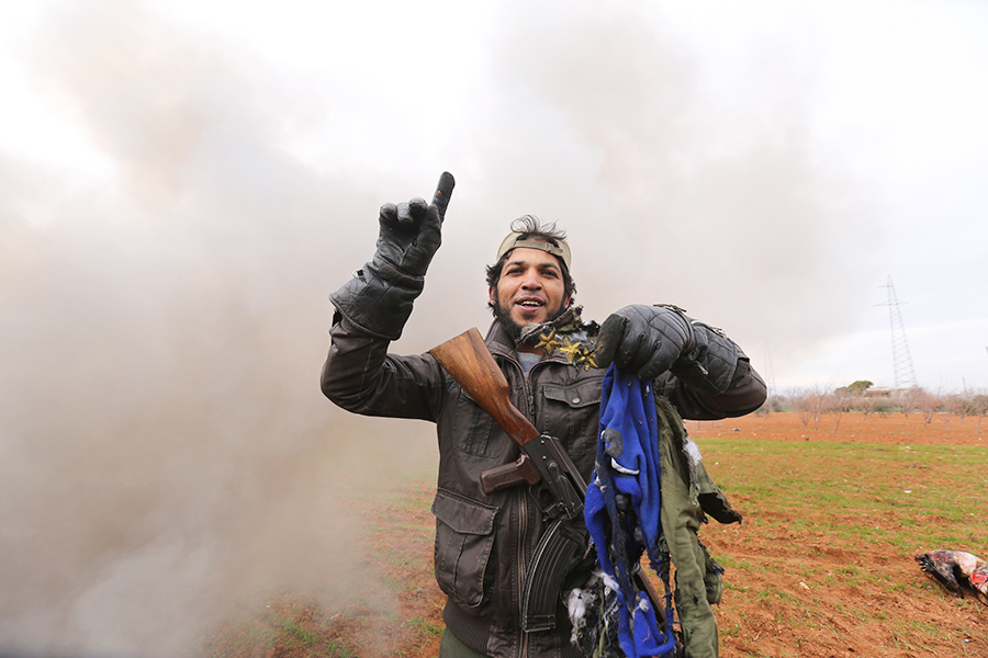 Солдат сопротивления держит в руках униформу пилота сирийских вооруженных сил
