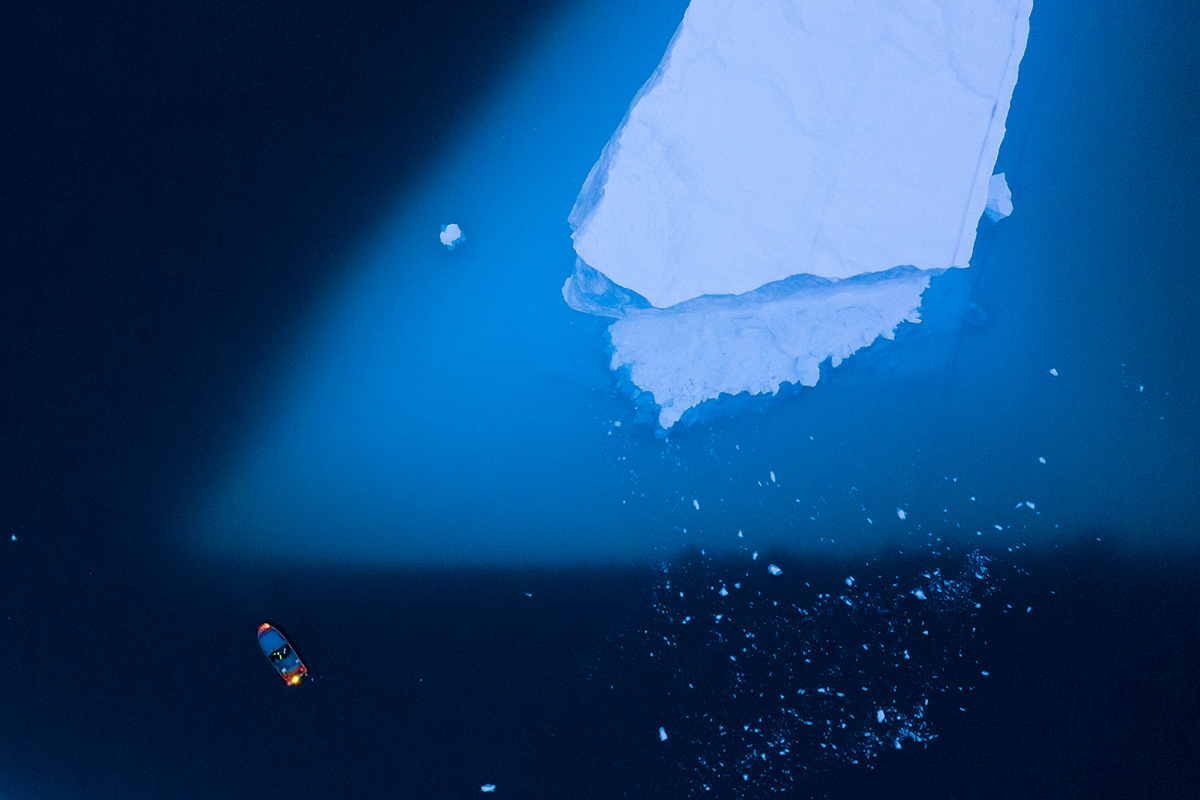 Исследовательская лодка приближается к айсбергу у восточного побережья Гренландии