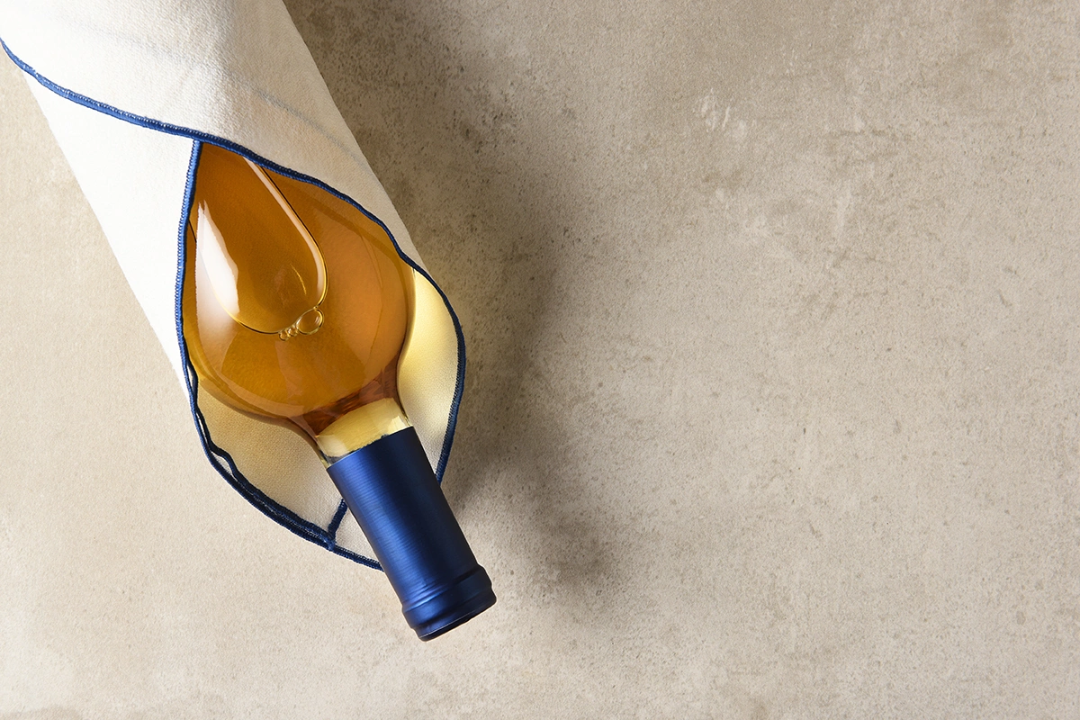 Бутылку вина можно упаковать даже в симпатичную столовую салфетку, красивое кухонное полотенце, винтажный шелковый платок и даже смешные носки