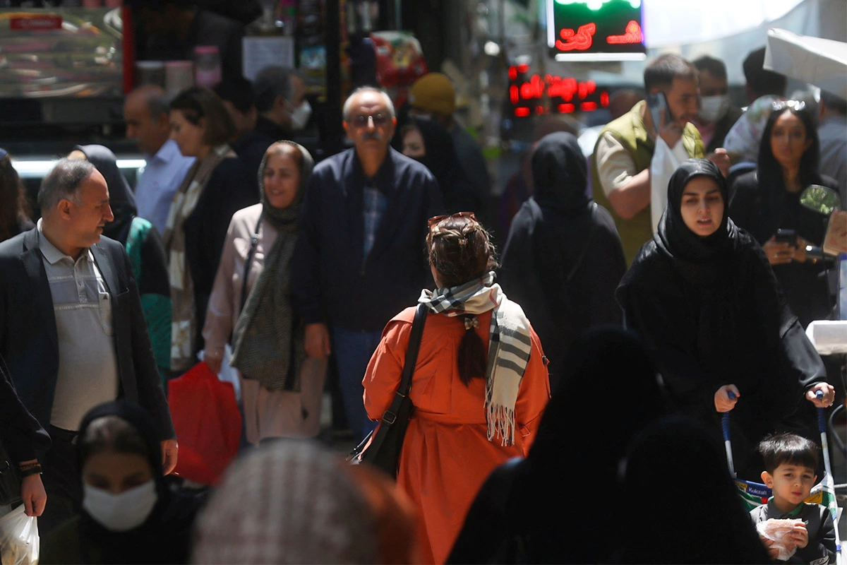 Иранская женщина с непокрытой головой идет по улице