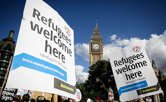 Люди держат плакаты во время демонстрации в поддержку беженцев в Лондоне, Великобритания