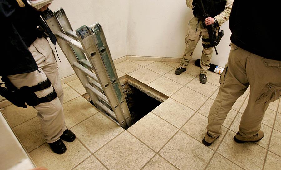 Сотрудники Иммиграционной и таможенной службы США охраняют вход в наркотуннель, обнаруженный на складе вдоль границы Мексики и США в Отай-Меса, Калифорния, 30 января 2006 года