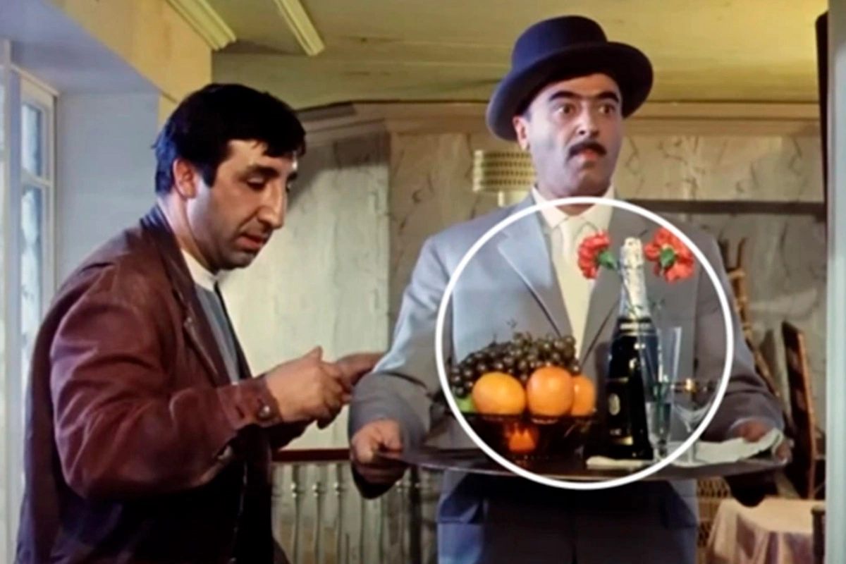 Товарищ Саахов заходит с подносом, на котором стоит бутылка шампанского. Кадр из фильма «Кавказская пленница, или Новые приключения Шурика»