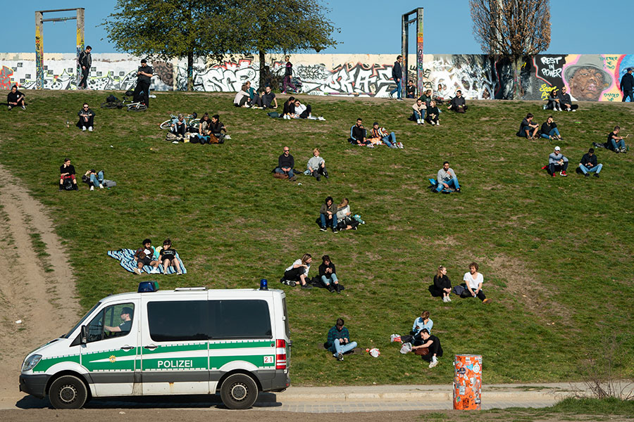 Полицейский патруль в одном из парков Берлина проверяет соблюдение гуляющими дистанции. В Германии из-за эпидемии запрещено собираться группами больше двух человек

