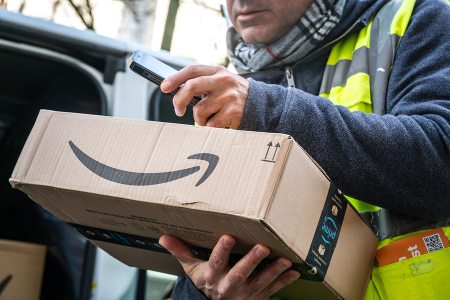 Сотрудник доставки Amazon Prime в Берлине, сканирующий штрих-коды на коробках