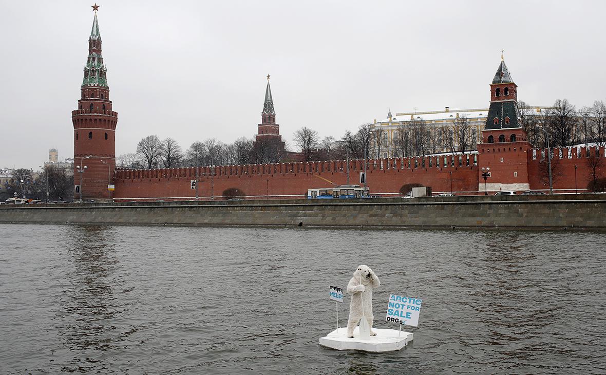 Активист организации Greenpeace в костюме белого медведя плывет на искусственной льдине по Москве-реке во время проведения акции &laquo;Арктика не продается!&raquo; напротив Московского Кремля в 2013 году
