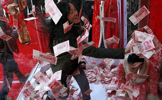 Женщина пытается поймать банкноту в сто юаней&nbsp;на аттракционе в преддверии праздника весны. Ханчжоу, Китай


