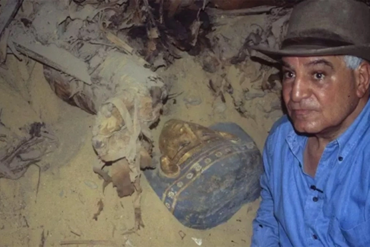 Египетский археолог позирует рядом с одним из саркофагов, недавно обнаруженных возле гробницы Тутанхамона