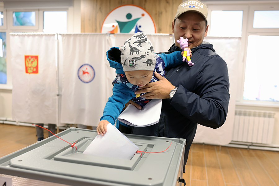 Мужчина с ребенком голосует во время выборов главы Республики Саха (Якутия) в Якутске