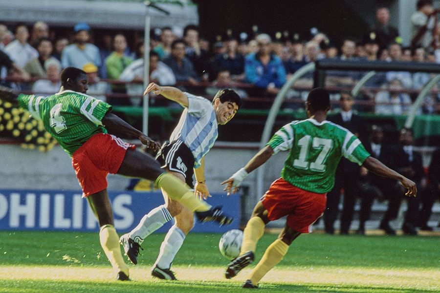 Камерунские футболисты Бенджамин Массинг и Виктор Н'Дип (спиной к камере) бросают вызов аргентинскому футболисту Диего Марадоне во время матча группы B чемпионата мира по футболу FIFA 1990 года между Аргентиной и Камеруном на стадионе «Сан-Сиро»