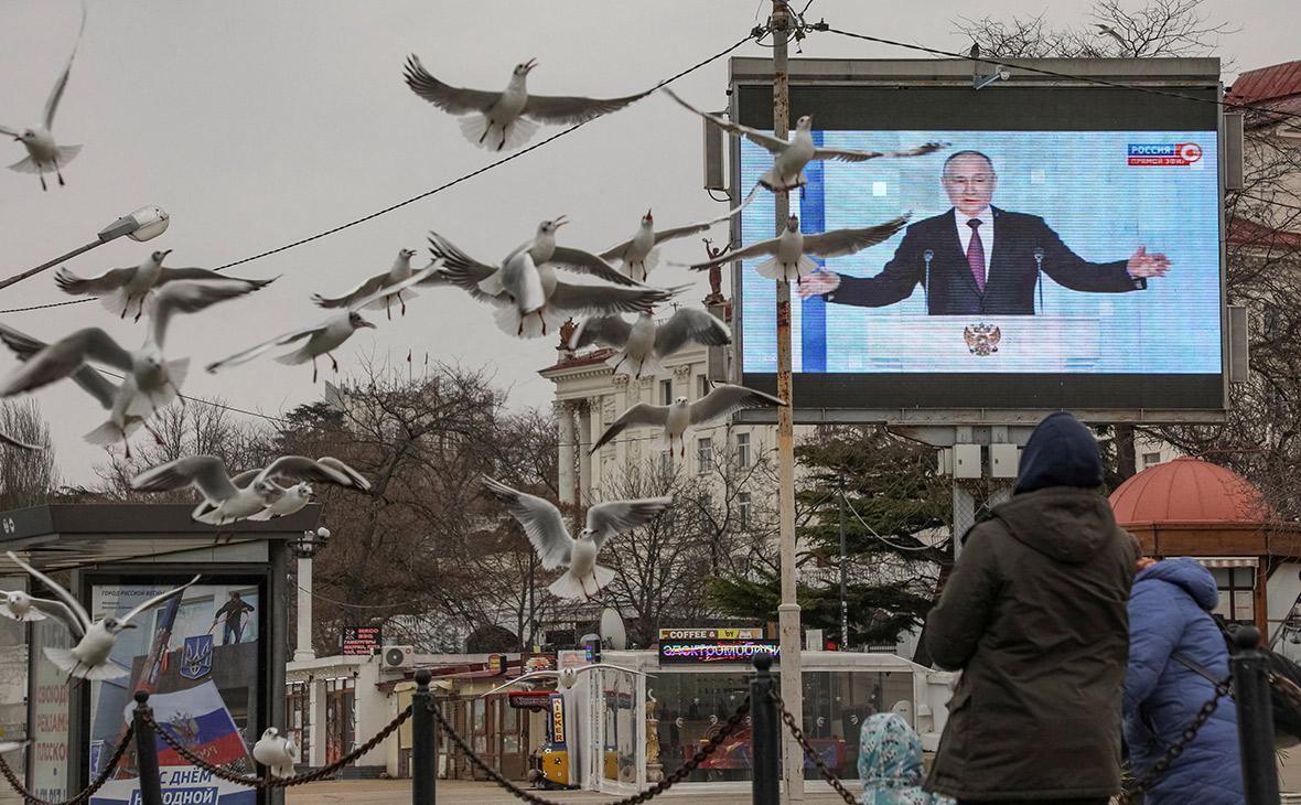 Владимир Путин на экране во время своего обращения к Федеральному собранию