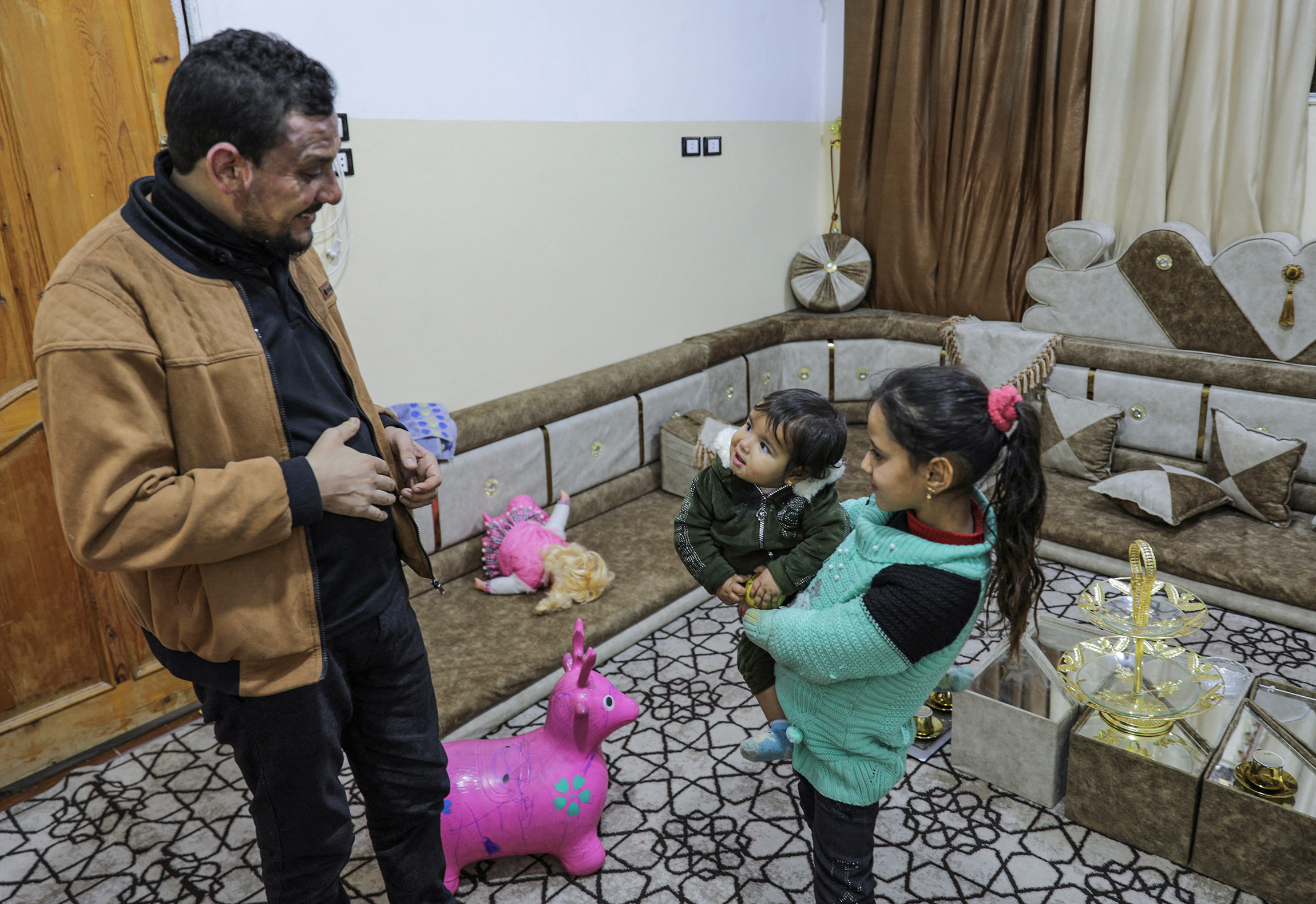 Девочка Афраа, родившаяся незадолго до землетрясения, со своим дядей. В результате катастрофы погибли ее родители, братья и сестры. Город Джандарис, Сирия, 24 января.