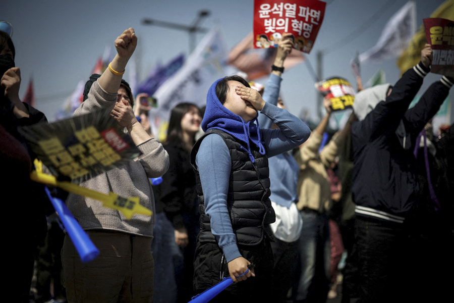 Люди празднуют импичмент президента Южной Кореи Юн Сок Ёля возле здания Конституционного суда в Сеуле. 4 апреля 2025 года Конституционный суд страны единогласным решением поддержал отстранение главы государства от должности. После этого в стране провели досрочные выборы, на которых победу одержал лидер Демократической партии Ли Чжэ Мён.