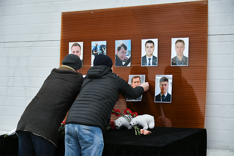 Мужчины у телевизионного центра &laquo;Останкино&raquo; вешают фотографии журналистов, погибших при&nbsp;крушении самолета Ту-154
