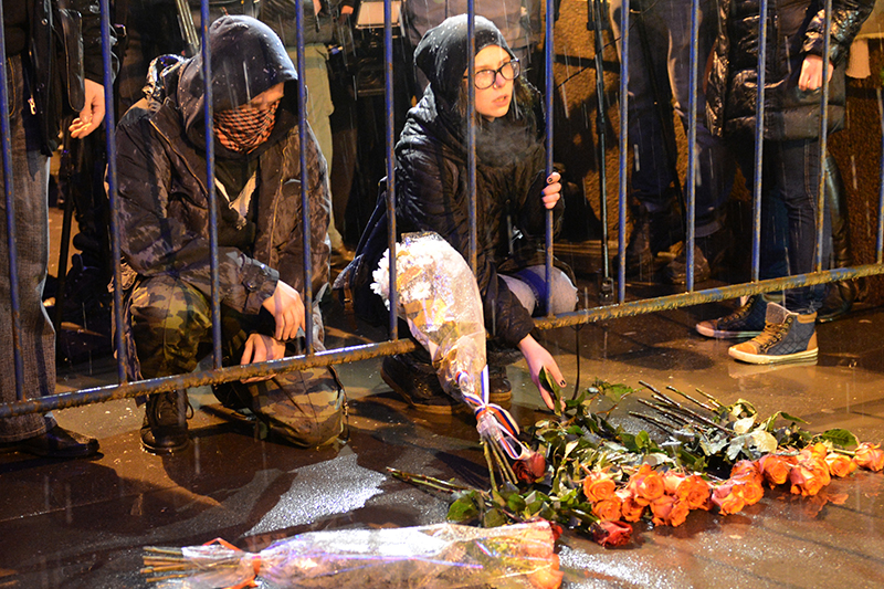 Люди несут цветы к месту убийства политика Бориса Немцова