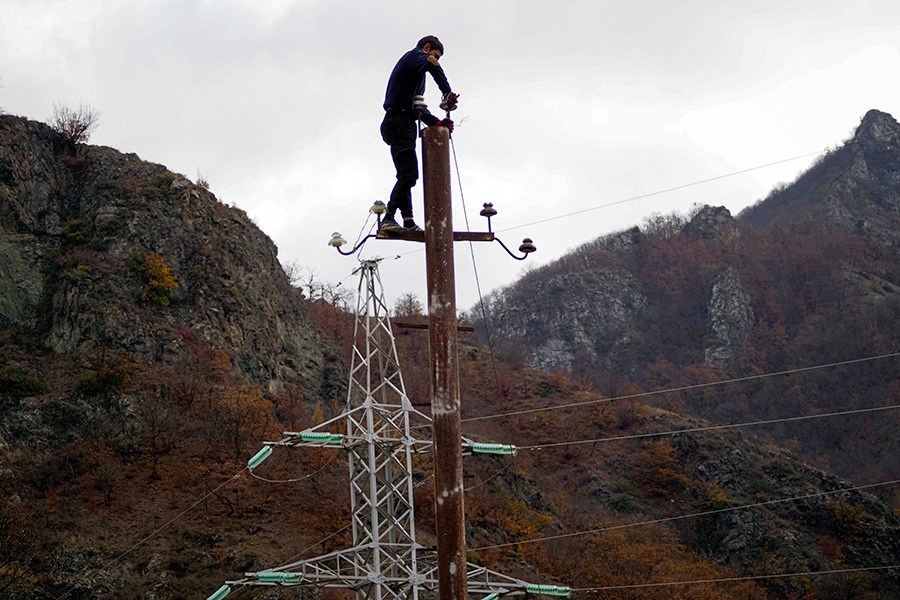 Мужчина снимает провода в районе, переходящим под контроль Азербайджана.&nbsp;