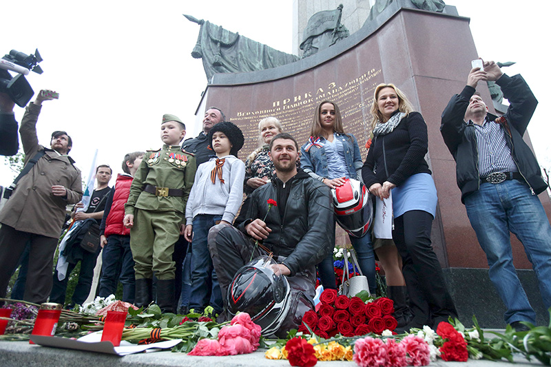 Российские мотоциклисты и их сторонники позируют на фоне памятника героям Советской армии в Вене