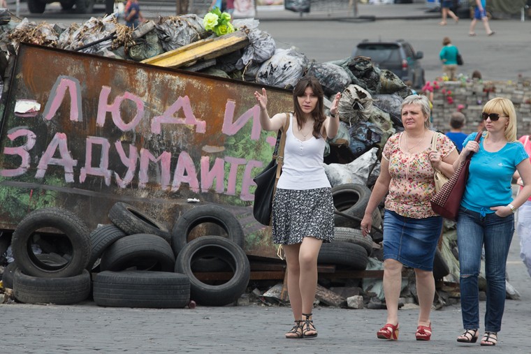 Люди гуляют вдоль баррикад в центре Киева. Спонтанные свалки, разобранная брусчатка и горы покрышек также являются причинами для недовольства обычных горожан. 