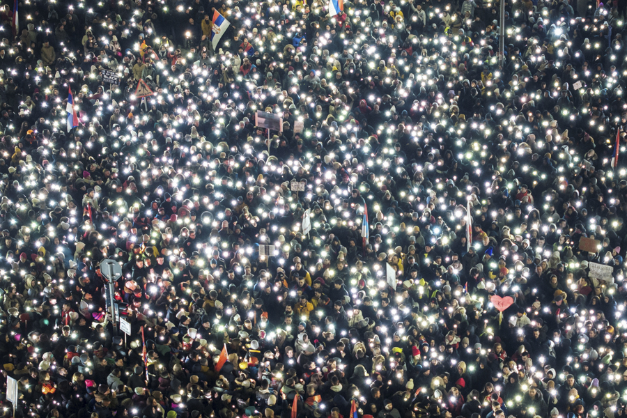 Протестующие сербские студенты в Крагуеваце во время 15-минутного молчания в память о погибших в Нови-Саде. 1 ноября 2024 года на недавно отремонтированном железнодорожном вокзале города обрушился навес, в результате чего погибли 16 человек. После этого в стране начались протесты. Демонстранты потребовали наказать виновных в трагедии, жестче бороться с коррупцией и объявить досрочные выборы. Президент Сербии Александр Вучич объяснил происходящее попытками Запада устроить &laquo;цветную революцию&raquo; в республике. 15 февраля 2025 года.