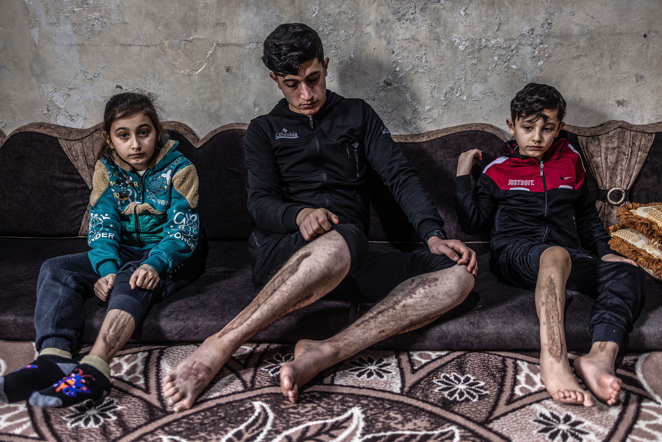 Алаа, Мустафа и Мохаед Ганнам, которые получили ранения в результате обрушения здания во время землетрясения, деревня Азмарин в Сирии, 28 января.