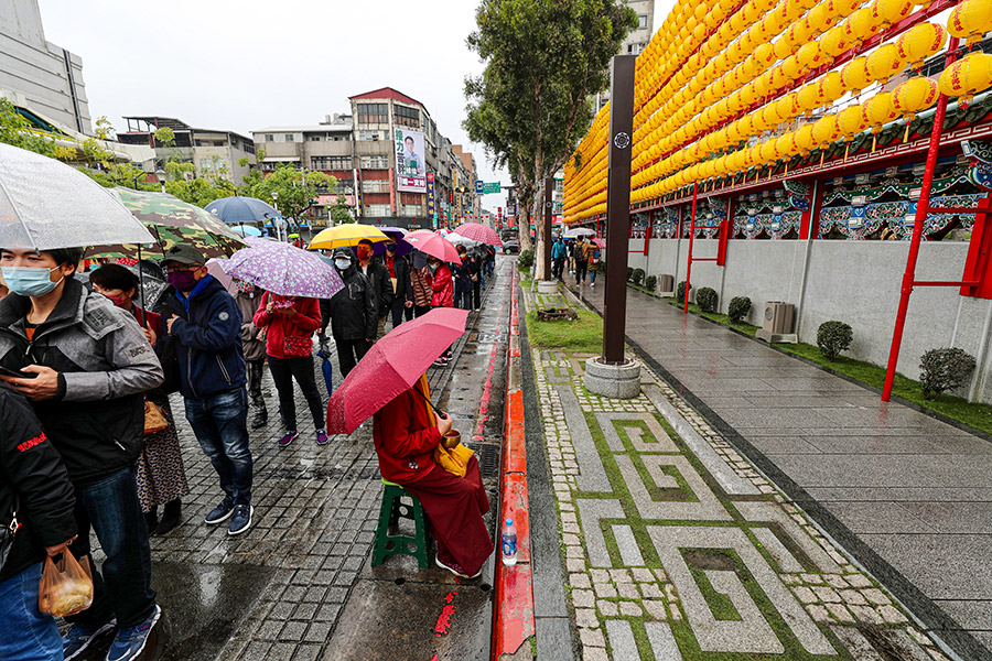 Тайбей, Тайвань. Люди ожидают в очереди в буддистско-даосский храм Луншань, чтобы помолиться на церемонии