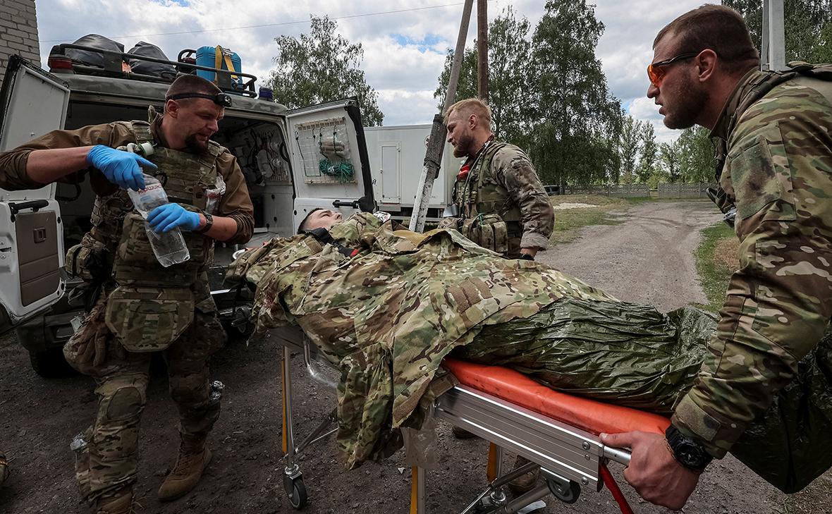 Военные медики оказывают помощь раненому украинскому военнослужащему, недалеко от города Волчанск в Харьковской области