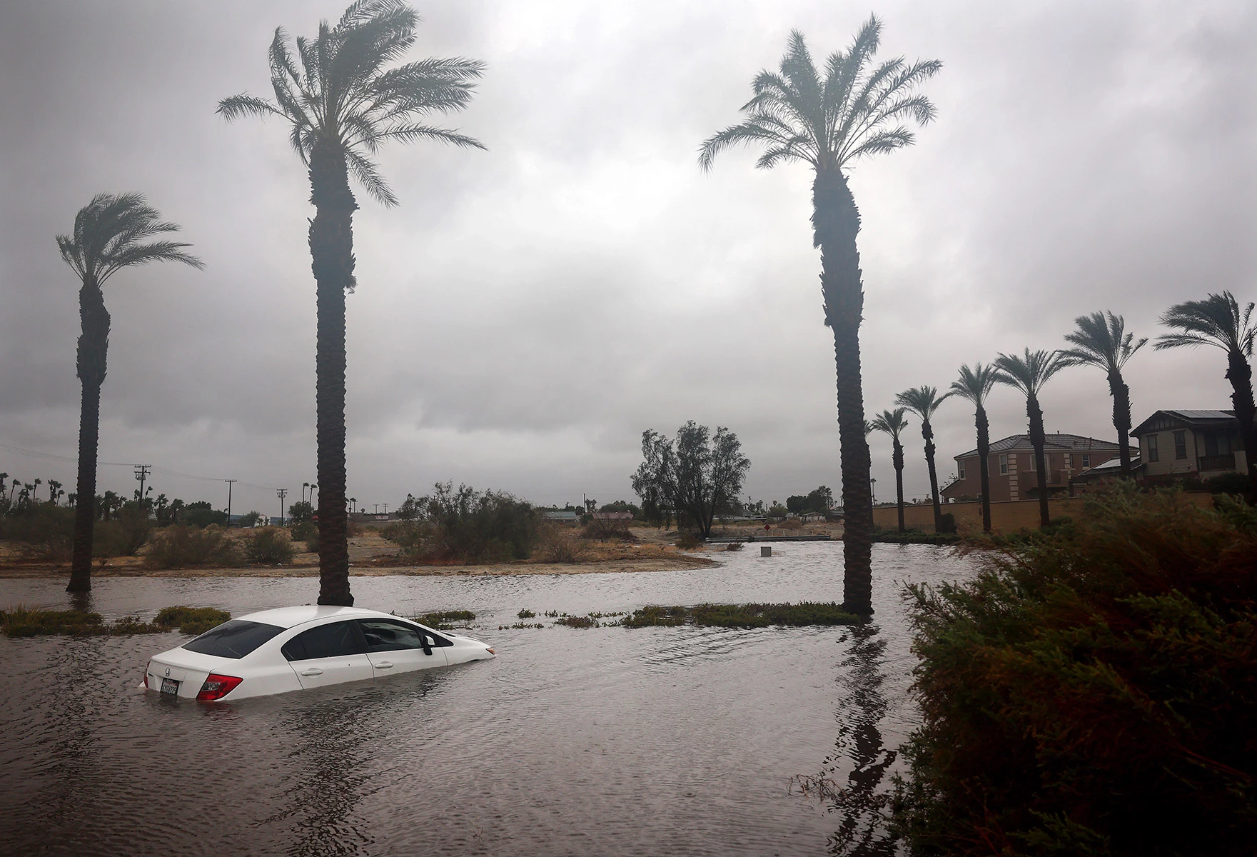 <p>Частично затопленный паводковыми водами автомобиль в Катидрал-Сити в Калифорнии. Из-за шторма властям пришлось полностью закрыть пляжи в ряде округов</p>