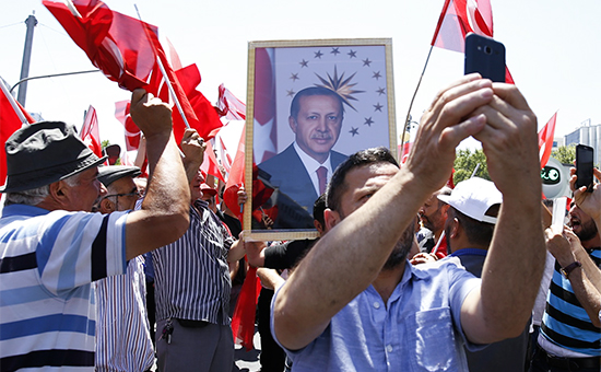 Сторонники президента Эрдогана с его портретом на улице Анкары. 16 июля 2016 года


