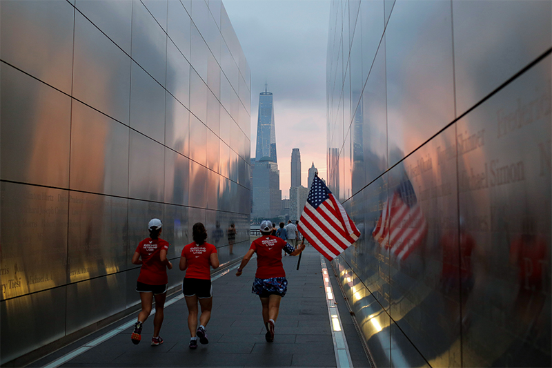 Люди с&nbsp;флагом США бегут сквозь&nbsp;государственный мемориал &laquo;Пустое небо&raquo; в&nbsp;Нью-Йорке, посвященный памяти жертв терактов 11 сентября. Нью-Йорк, США
