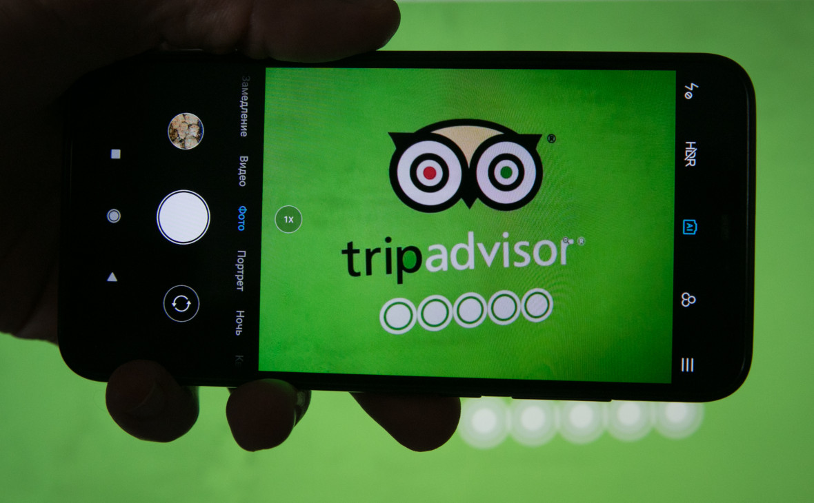 Логотип приложения TripАdvisor на экране смартфона