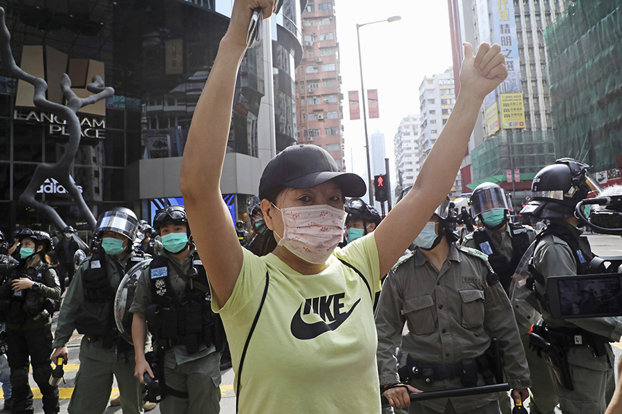 Провластная активистка&nbsp;выкрикивает лозунги в поддержку действий полиции&nbsp;во время сбора участников акции протеста в Гонконге
