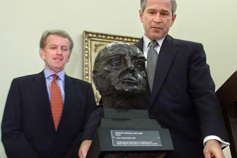 Бывший президент США Джордж Буш&nbsp;устанавливает бюст Уинстона Черчилля, переданный британским послом Кристофером Мейером (слева), в Овальном кабинете. Фото&nbsp;16 июля 2001 года


