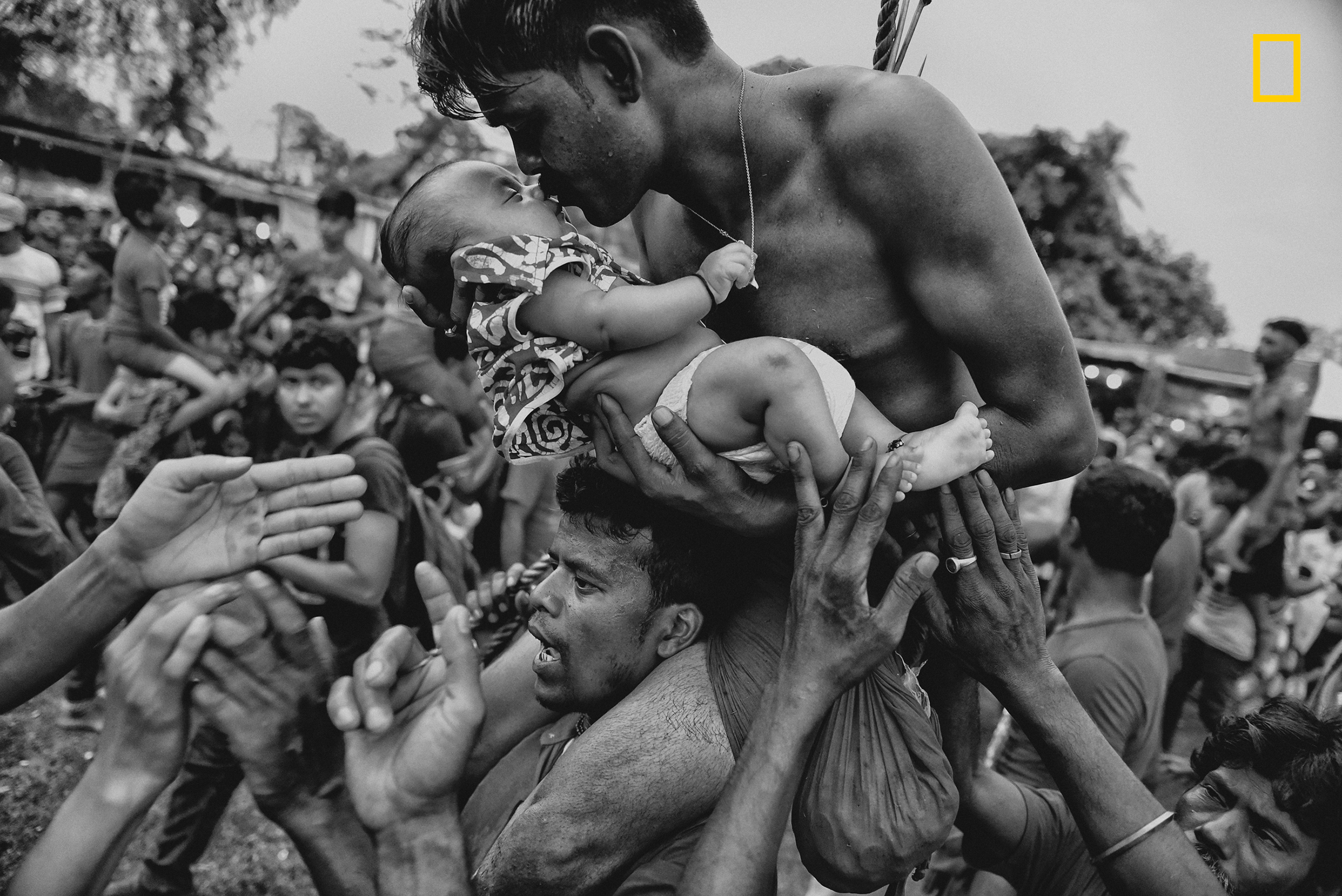 Молодой человек целует своего маленького сына во время праздника Чарак Пуджа (народный фестиваль в Индии и Бангладеш&nbsp;в честь бога Шивы)
