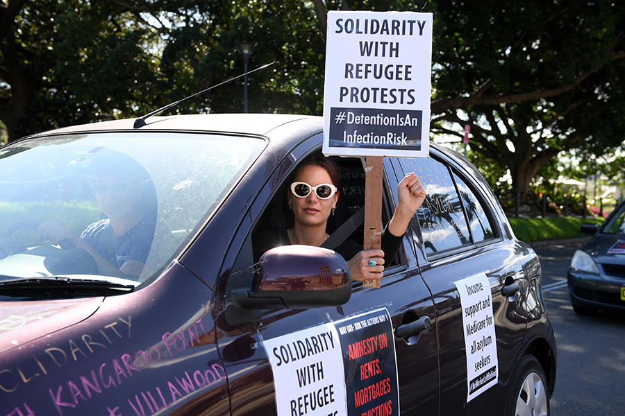 Участница первомайской акции протеста в австралийском Сиднее выражает солидарность с беженцами
