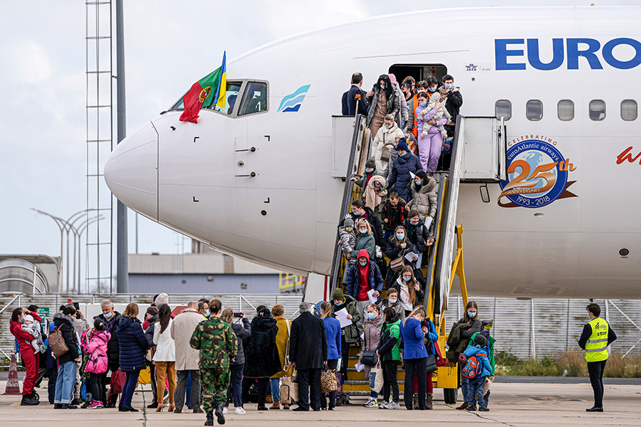 На фото: украинские беженцы спускаются с самолета, прибывшего из Польши в военный аэропорт Лиссабона, Португалия, 10 марта.