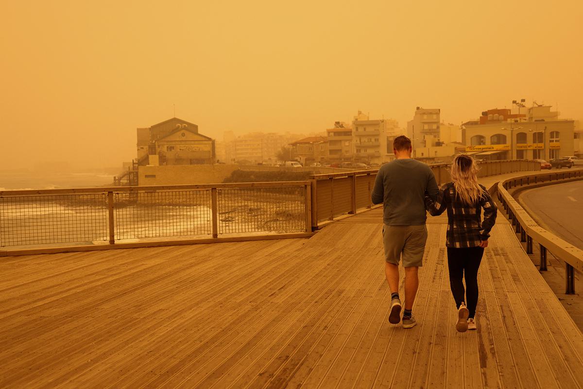 Люди идут в дымке, вызванной песчаной пылью из Сахары из-за сильных южных ветров, в Ираклионе, остров Крит, Греция, 1 апреля 2026 года
