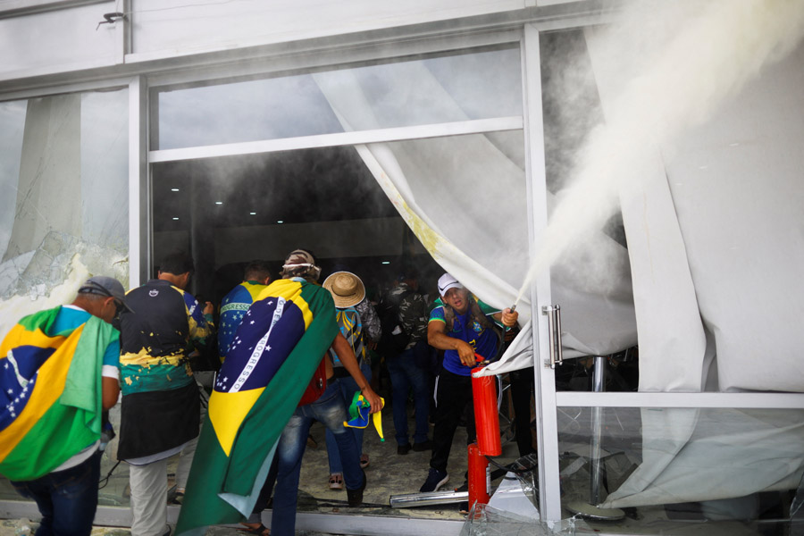 Протестующие с бразильскими флагами били стекла в зданиях, и, проникая внутрь, совершали там акты вандализма.